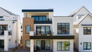 Ein modernes, mehrgeschossiges Wohngebäude mit Flachdach, großen Fenstern und einem Balkon.
