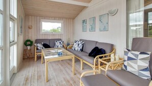 A cozy room with a sofa set, a glass-top coffee table, and wicker chairs. - "Allis" - 400m from the sea by Interhome (Fanø)
