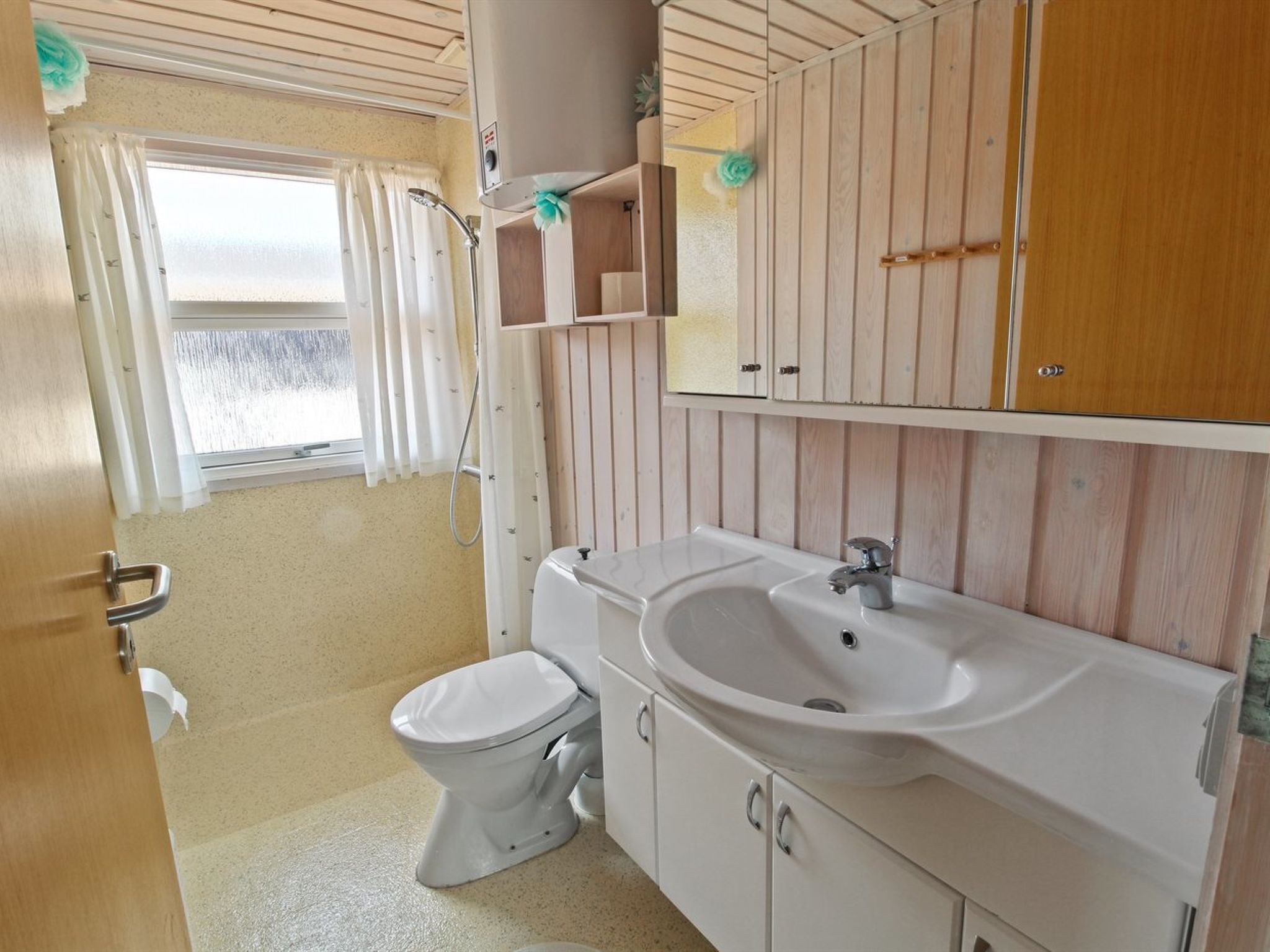 A compact bathroom with a toilet, sink, and shower.