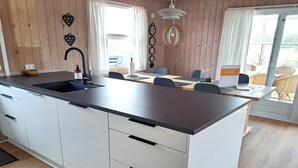 A modern kitchen with a central island, white cabinetry, and a dark countertop. - "Allis" - 400m from the sea by Interhome (Fanø)