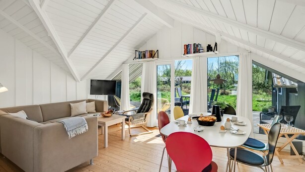 A modern loft-style living space with a high ceiling, a dining area with a round table and chairs, a sofa, and a TV. - "Maxie" - 1.2km from the sea by Interhome (Fanø)