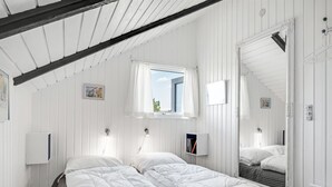 A bedroom with two beds, a window with curtains, a mirror, and a radiator. - "Maxie" - 1.2km from the sea by Interhome (Fanø)