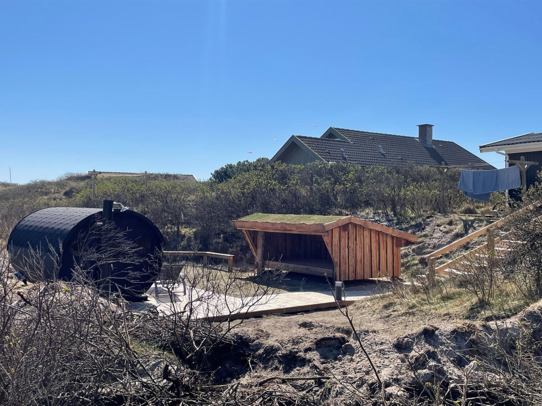 A house with a sloped roof, a wooden deck, and a small shed.