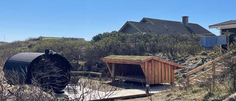 A house with a sloped roof, a wooden deck, and a small shed.