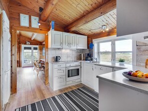 A modern kitchen with white cabinets, a large window, and a view of the outdoors. - "Anton" - 1.5km from the sea by Interhome (Fanø)