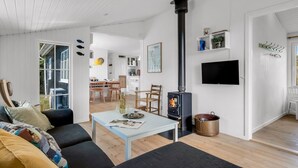 A modern living room with a sofa, a coffee table, and a fireplace. - "Neija" - 800m from the sea by Interhome (Fanø)