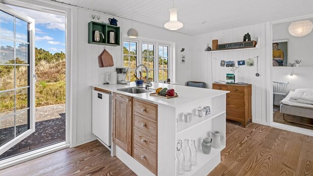 A modern kitchen with a central island, wooden cabinets, and a view of the outdoors. - "Neija" - 800m from the sea by Interhome (Fanø)