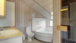 Et lille badeværelse med vask, toilet og badekar.