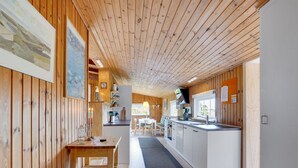 A cozy cabin interior with a wooden interior, a dining area, and a kitchenette. - "Stefana" - 200m from the sea by Interhome (Fanø)