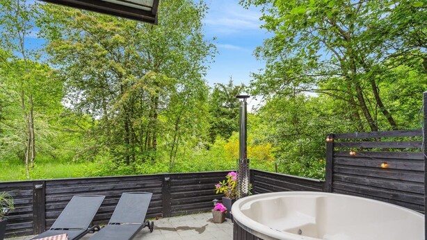 A patio with two lounge chairs, a hot tub, and a wooden bench. - "Nyalle" - 30km from the sea by Interhome (Toftlund)