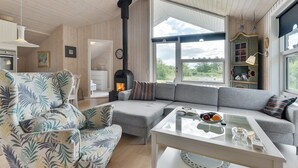 A cozy living room with a large window, a fireplace, and a modern sofa. - "Estrid" - 30km from the sea by Interhome (Toftlund)