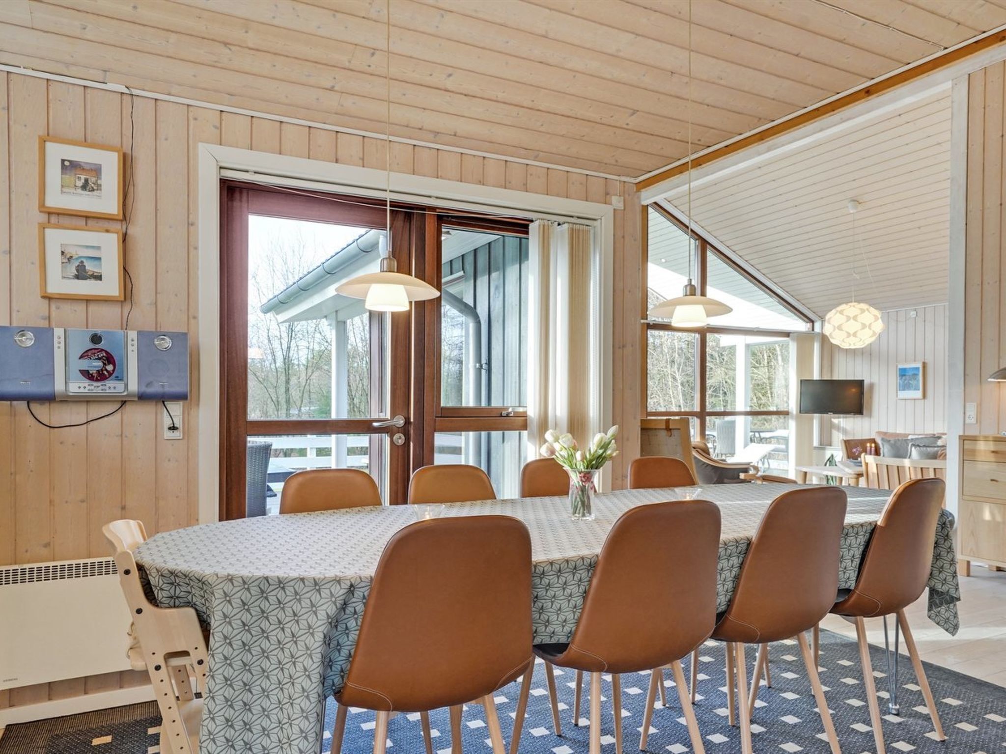 A dining area with a table set for six, surrounded by wooden chairs.