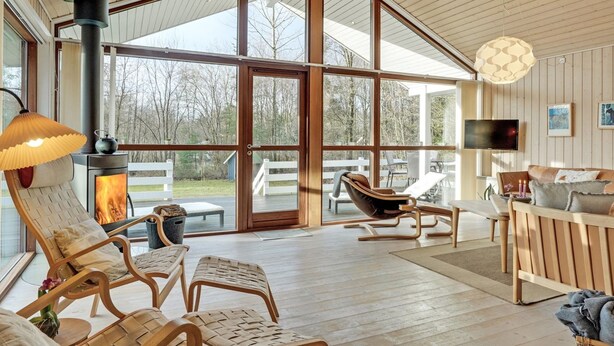 A spacious living area with a large fireplace, comfortable seating, and a television.