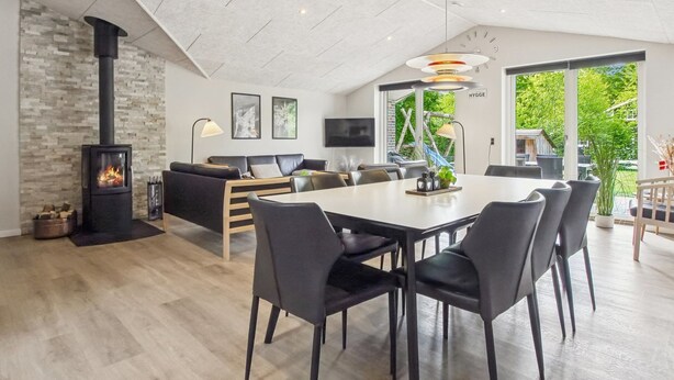 Un espacio habitable moderno con chimenea, comedor, sofá y televisor.
