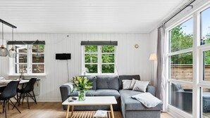 A modern living room with a grey sectional sofa, a wooden coffee table, and a dining area with a table and chairs. - "Helghi" - 30km from the sea by Interhome (Toftlund)