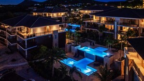 Un complexe hôtelier comprenant plusieurs bâtiments, une piscine et un paysage montagneux en toile de fond.