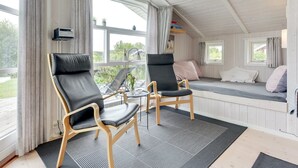 A cozy room with two leather chairs, a small table, and a bed with pillows. - "Tjakko" - 900m from the sea by Interhome (Sydals)