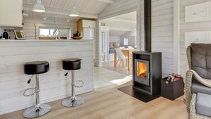 A modern kitchen with white cabinets, a built-in oven, and a large window.