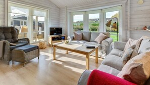 A spacious living room with a large sofa, a coffee table, and a television.