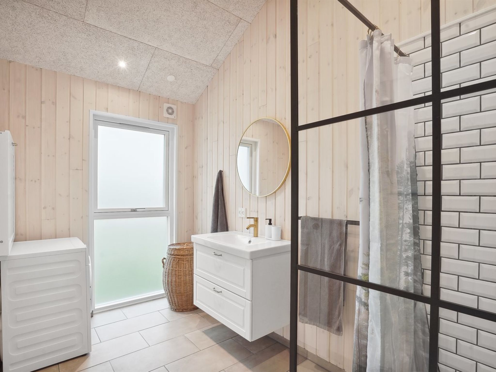 A bathroom with a white vanity, a mirror, and a shower area with a glass door.