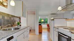 A modern kitchen with white cabinets, a granite countertop, and stainless steel appliances. - "Umen" - 300m from the sea by Interhome (Sydals)