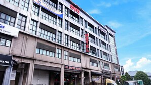 Un edificio de varios pisos con letreros que indican OYO, K.L. Empire Hotel y un hotel llamado Hotel H.
