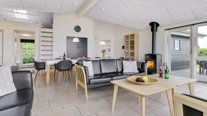 Ein modernes Wohnzimmer mit Kamin, Essbereich und Küche.