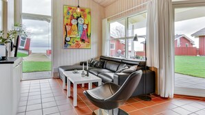 Een moderne woonkamer met een bank, salontafel en een schilderij aan de muur.