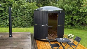 A wooden deck with a black outdoor structure, a table, and two chairs. - "Leefke" - 300m from the sea by Interhome (Sydals)