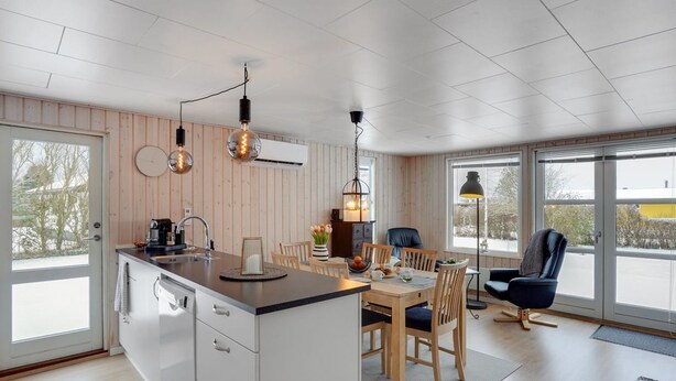 A modern kitchen with a central island, wooden panel walls, and pendant lighting. - "Leefke" - 300m from the sea by Interhome (Sydals)