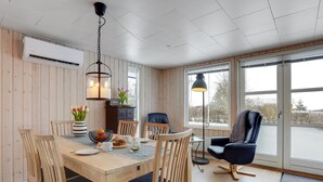 A cozy dining area with a wooden table, chairs, and a hanging light fixture. - "Leefke" - 300m from the sea by Interhome (Sydals)