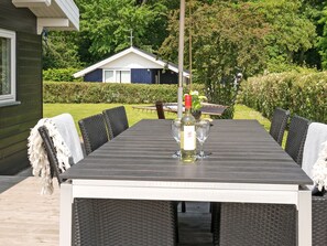 A rectangular outdoor table with six chairs, a bottle of white wine, and two glasses. - "Ølwir" - 400m to the fjord by Interhome (Egernsund)