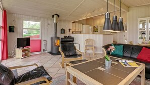 Een gezellige woonkamer met een open haard, lederen meubels en een eethoek.