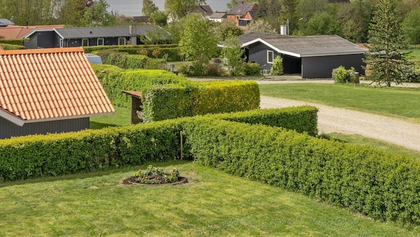 A residential area with houses, a garden, and a body of water in the background. - "Guldborg" - 400m to the fjord by Interhome (Egernsund)
