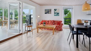 A modern living room with a sofa, coffee table, and dining area.