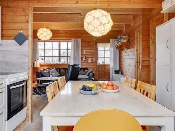Cozy cabin-style room with a dining table, kitchen area, and comfortable seating space.