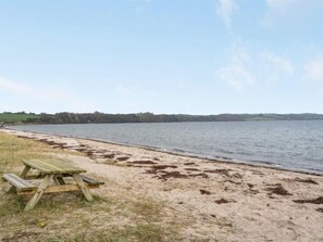 Relax by the serene lake with a picnic table and bench, surrounded by natural beauty and scenic views.