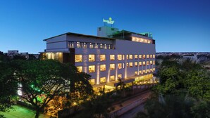 A multi-story hotel with a modern architectural design, featuring a prominent rooftop sign and illuminated windows. - Lemon Tree Hotel Hubli (Hubli)