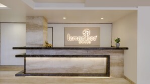 A reception desk with a marble top and a sign reading "lemon tree hotel". - Lemon Tree Hotel Hubli (Hubli)