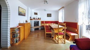 A dining area with a wooden table and red cushioned benches. - Vineyard cottage Cvitkovič (Crnomelj)