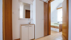 A bedroom with a wooden wardrobe, a bedside table, and a bed. - Vineyard cottage Cvitkovič (Crnomelj)