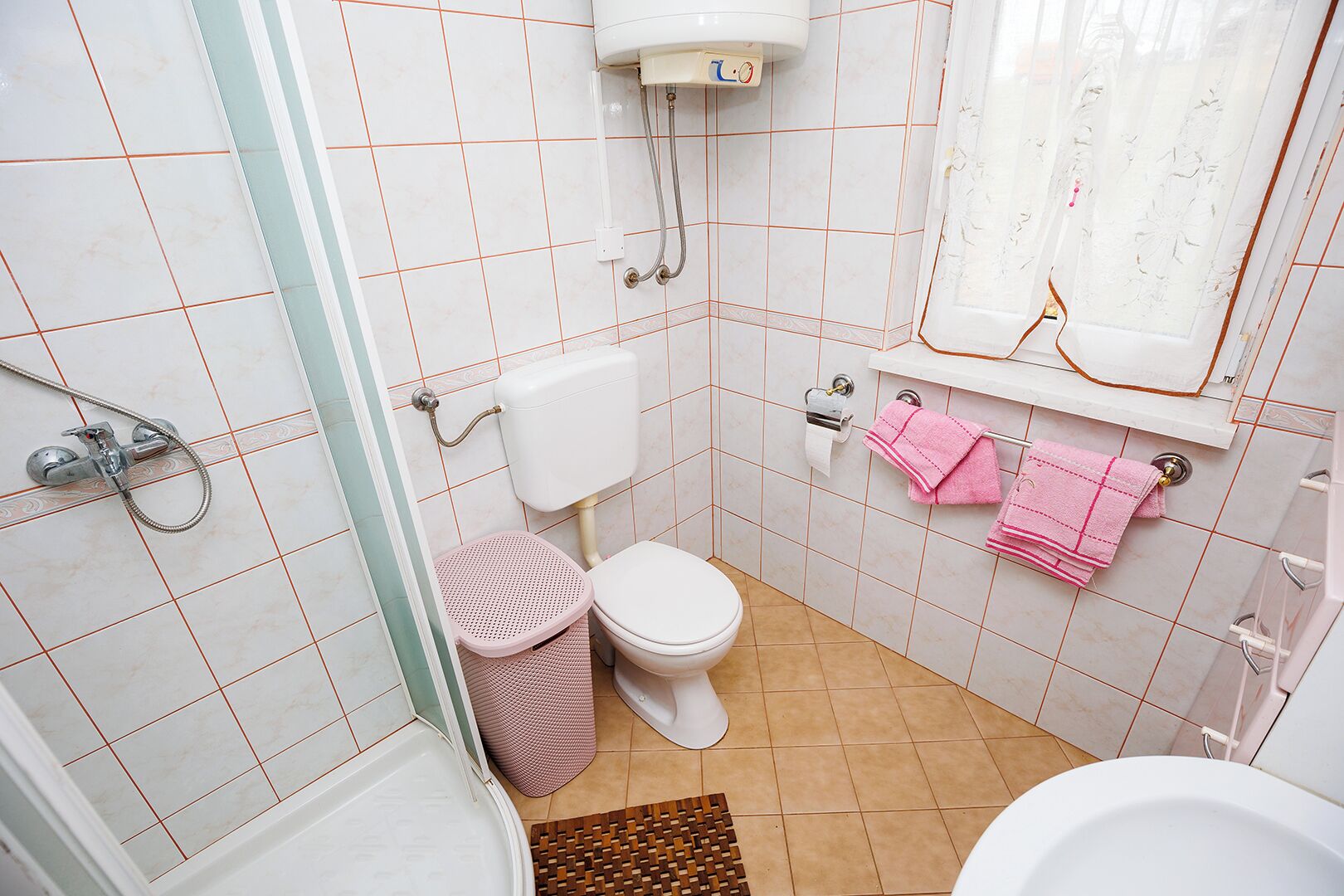 A small bathroom with a toilet, a bidet, a shower, and a sink.