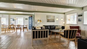 A spacious living area with a wooden floor, a sofa, a coffee table, and a dining area with chairs and a table. - "Ingulf" - 18km from the sea by Interhome (Bredebro)