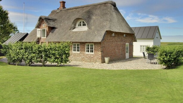 A traditional thatched-roof house with a brick exterior, a small window, and a chimney. - "Ingulf" - 18km from the sea by Interhome (Bredebro)