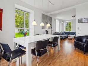 Un intérieur moderne comprenant un coin repas, un canapé et une vue sur la verdure.