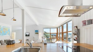 Une cuisine moderne dotée d’une grande fenêtre, d’un évier encastré et de meubles de rangement en bois.