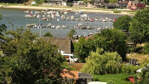 Un port de plaisance où sont amarrés des bateaux, entouré de bâtiments résidentiels et de verdure.