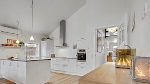 A modern kitchen with white cabinetry, a wooden island, and a built-in oven. - "Holmwith" - 200m from the sea by Interhome (Aabenraa)