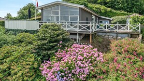 Ein modernes Gebäude mit Glasfassade, einer Holterrasse und einer Fahnenstange.