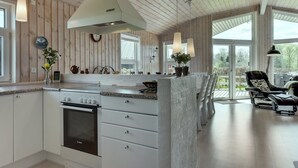 Een moderne keuken met een centraal eiland, witte kasten en een ingebouwde oven.